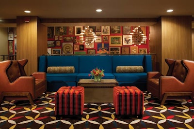 A sitting area outside the meeting rooms has colorful furniture, Wi-Fi, and computer stations.