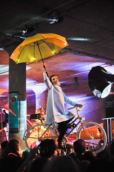 Another spinning vehicle has a vignette of a performer on a vintage bicycle, clutching a lit-up umbrella.