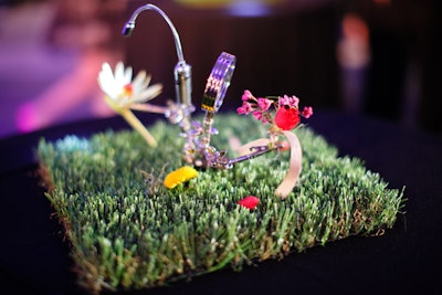 On highboy tables throughout the general receptions space, unusual centerpieces included flowers and bits of machinery sprouting from patches of grass. Other tables held jars filled with tiny winged ladders.