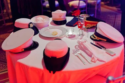To represent the servicemembers who couldn't attend due to deployment or death, organizers decorated a single white table near the stage with hats for each branch of the military.