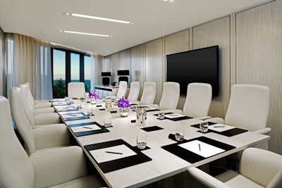 A meeting space with views of the ocean and cream-colored furnishings.