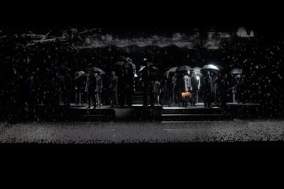 As the holographic projections moved the scene from spring to winter, models subtly responded to the changing seasons by adding sunglasses or turning up their collars. The finale brought in a sudden snowstorm, and umbrellas went up simultaneously as models were encased inside a giant snow globe shaking with snow.