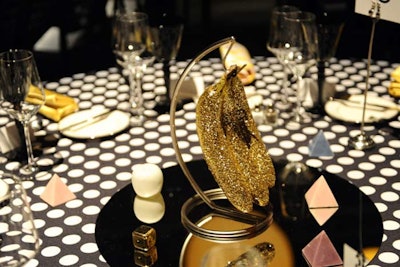 For the Redcat gala, Two Serious Ladies designed the artful decor that included a constellation of golden, glowing orbs hanging above the main room and centerpieces made of glittering bananas, toy horseshoes, marble pyramids, and golden dice.