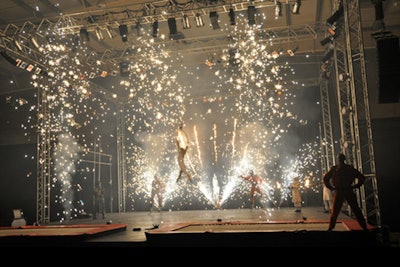 Pyrotechnic, mad-cap stunt show with bouncing stilts, bungee, architecture
