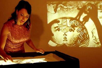 Sand artist who projects her artistic images on large screen