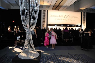 Decor in the reception area included strings of crystal beads designed into the shape of champagne glasses, with large photo frames highlighting 25 years of Leukemia Ball photos.