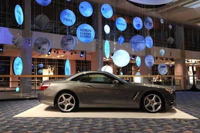 Automobiles from Mercedes-Benz were showcased throughout the venue, including in front of a mobile displaying the event's sponsors.