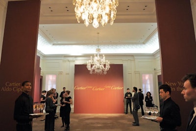 On the second floor, custom walls framed the main cocktail space, vertical pieces that also served loosely as an informal step-and-repeat. The entrance to the exhibition stood to the left, while the right side of the site held a comfortable lounge and bar in the area typically used as the customer service reception.