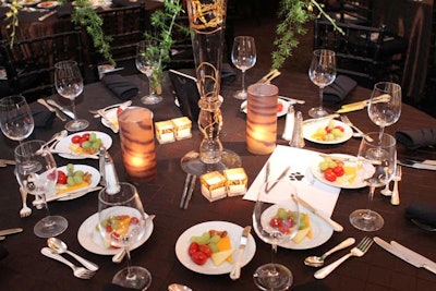 Dinner tables held pillar candles in tiger-print containers. Leaves cascaded down from the Flower Firm's towering arrangements.