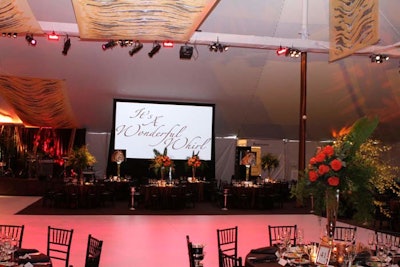 The tiger-print theme continued in drapes suspended from the ceiling. Along one wall, a giant screen showcased live auction items and action from the evening, including the cheetah's stroll around the dance floor.