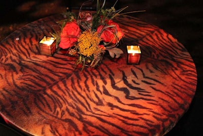 Another touch of tiger print appeared in linens covering low cocktail tables. Loosely arranged flowers and candlelight added to the elegant-jungle look.