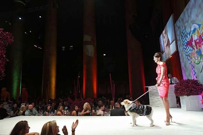 Walkers in the fashion show hit the runway with their dogs after raising a minimum of $5,000 to participate.