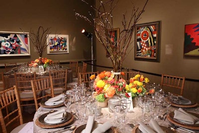 Jack Lucky created nature-inspired centerpieces for one of the brown galleries with birchwood branches surrounded by low yellow, orange, and pink flowers.