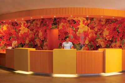 Brightly colored, flower-patterned wallpaper backs the reception desk.