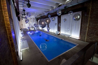 The indoor pool area, located on the second floor of the venue, was decorated with large clear and silver balloons. A bar topped with a silver sequin table cloth stood at the far end of the room.