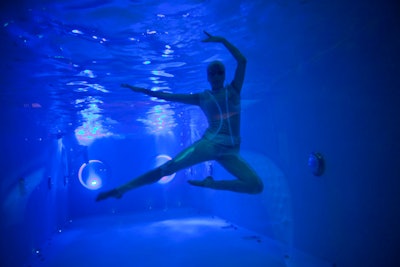 A trio of synchronized swimmers from Gotham Synchro swam in the venue's indoor pool, which was visible through a looking glass in the lobby. The water dancers sported custom metallic body suits with glow-in-the-dark trimming, outfits designed to make them look like aliens.