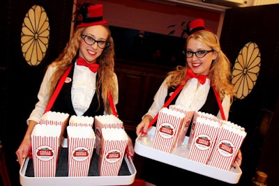 Servers in jaunty fedoras passed out movie snacks in boxes splashed with the beer brand's logo.