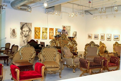 Plush sofas lined with golden accents paired with paintings on the wall at LMNT Contemporary Art Space gave the white runway and white walls pops of color.