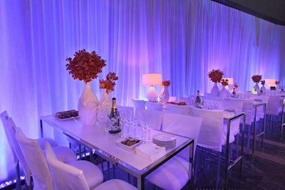 White high-top cocktail tables decorated with white vases that held red floral arrangements lined both sides of the space. Passed bites by Creative Edge Parties included mini pulled chicken sliders, raw tuna bites, and filet mignon bites. Each table also had its own Moet champagne bottle service.