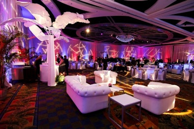 Animated club lights swirl around white couches and palm tree