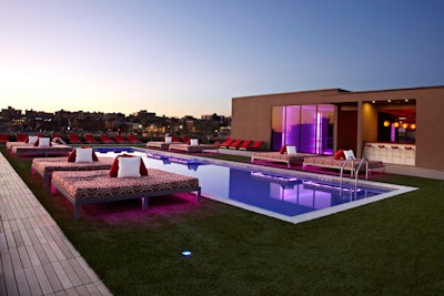 The Penthouse Pool Club's Moroccan design theme features platinum-colored lounge chairs with thick red cushions and red and white zebra-print daybeds circling the 60-foot pool.