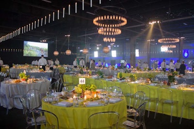 For lighting, the design team used more than 870 candles suspended from the ceiling. Several chandeliers were strategically placed throughout the dining room, including two different types of glass, globe-shaped fixtures. LED screens hung on either side of the room, giving guests a closer look at the stage presentation.