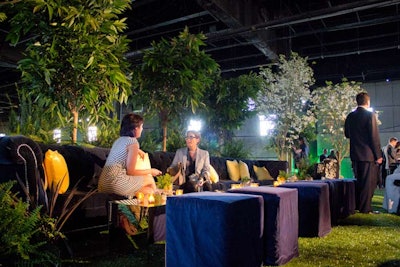 For additional seating, plush velvet couches lined both sides of the cocktail area. Candles and small plants decorated the tops of the mirrored tables.