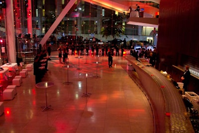 The post-show reception area was outfitted with glass cocktail tables, white streamlined furnishings, and red floral arrangements.