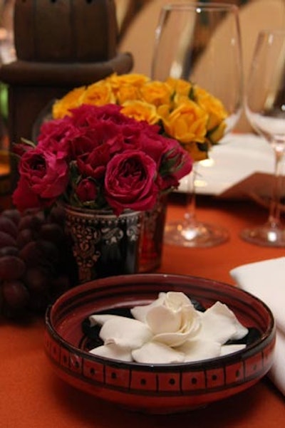 Tabletop decor also included grouped Moroccan tea glasses holding bouquets of colorful roses. At the end of the night, the bouquets and glasses were handed out as favors.