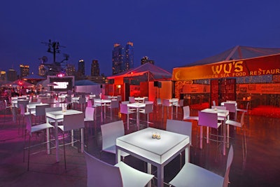 To contrast deck's gray flooring and help guests find their way in the dark, the production team used white chairs and sofas as well as illuminated tables.