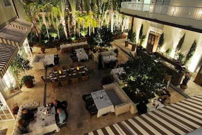Surrounded by palm trees, the 4,000-square-foot courtyard can seat 110 guests.