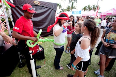 A balloon artist twisted rubber shapes and animals at the Verizon Wireless area.