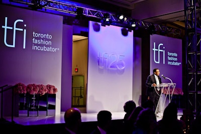 A three-dimensional T.F.I. logo marked the centre of the multipaneled runway backdrop in the V.I.P. area. Pink hydrangeas bordered the stage.