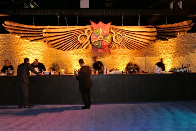 In the Babylonian space, a 40-foot stone wall was crested with a 32-foot golden-winged crest. In front of the wall, bartenders doled out drinks at a 42-foot rustic wooden bar.