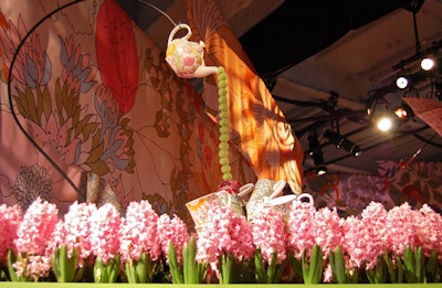 Larger-than-life props provided playful surfaces for the projection of flowery patterns at the Liberty of London launch. With 12,000 flowers, the space had overtones of an English garden, a look inspired by Lewis Carroll's classic English story Alice's Adventures in Wonderland.
