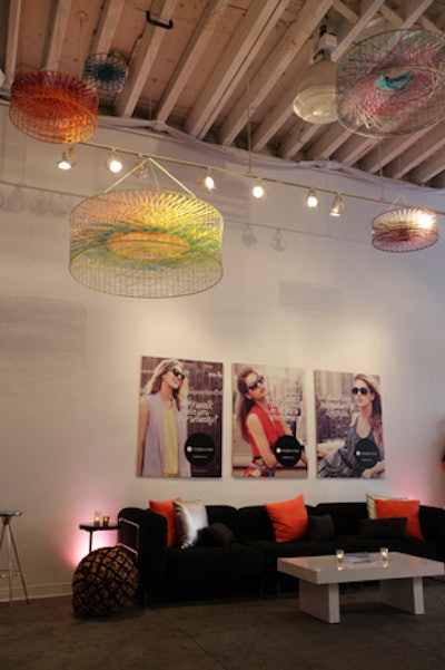The venue was outfitted in the brand's signature colors of black, white, and orange, with silver accents. Several promotional posters decorated the walls, and abstract, chandelier-like fixtures in bright colors hung from the ceiling.