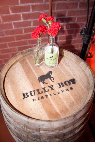 White lights were strung throughout the museum, illuminating the Bully Boy whiskey barrels that were used as high-boy tables. Each table was decorated with votive candles encircled with cigarettes and liquor bottles holding with red roses and carnations.