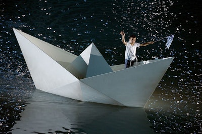 As part of the opening of the ceremony, a metal-framed, paper boat-shaped structure sailed in a pool filled with more than 530,000 gallons of water.