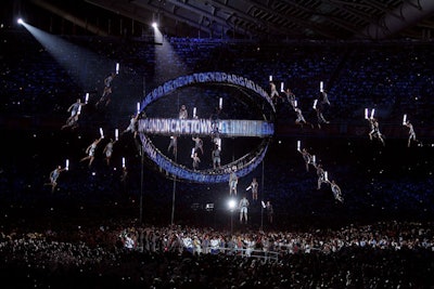 To represent the Olympic torch relay, Zolkwer and his team build a metal globe-shaped structure and suspended running performers around it.