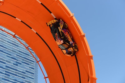 At the X Games, Hot Wheels set up a life-size replica of a double-loop stunt for toy cars. The giant orange race tracks were part of the 'Double Loop Dare,' which broke the world record when it brought two vehicles to race through a 66-foot double vertical loop. The stunt drivers, rally-car driver Tanner Foust and stuntman Greg Tracy, started on two different tracks and accelerated to 53 miles per hour before entering the loop, reaching seven times the force of gravity.