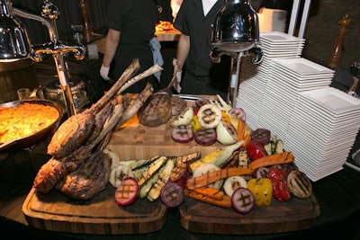 A carving station offered chef-carved, dry-aged, long-bone rib eye steak on carving boards.