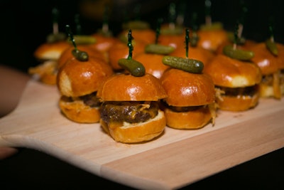 Passed snacks included mini burgers with truffle aioli, cheddar, and onion straws. The retro-style snacks were garnished with sandwich picks and cornichons.