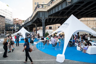 Several tents throughout the space mark the different stations, including a guest lounge, a skate-rental counter, and additional seating on highboys and transparent bar stools.