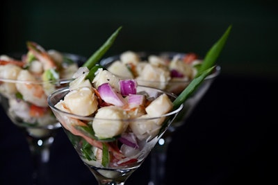 The Key West seafood martini includes poached jumbo shrimp, bay scallops, avocado, chopped red onions, peppers, and scallions, tossed in a tangy key lime dressing and served cold in a miniature martini glass.