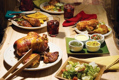 Party platter including a whole rotisserie chicken and side dishes like corn on the cob with Parmesan chili and chipotle sauce, and crushed baby potato tostones with truffle chimichurri, by Kokoriko Natural Rotisserie in Miami