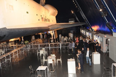 Inside the pavilion, guests were free to check out the decommissioned shuttle or grab food and drink from the bar and buffets before taking a seat at the tables placed beneath the ship's belly.