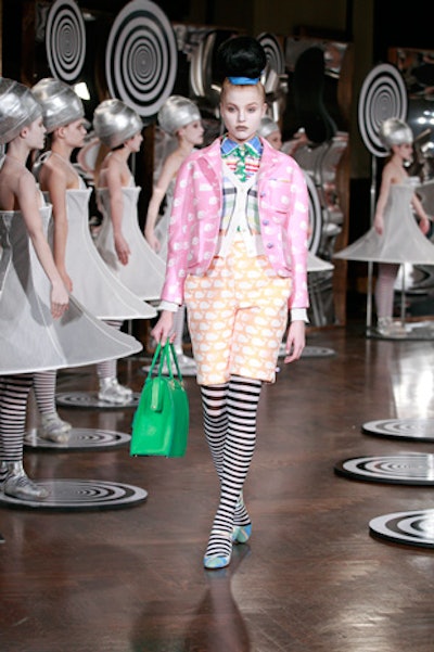 Inspired by the work of Bauhaus artist Oskar Schlemmer, a German known for his 'conceptual ballet' choreography, Thom Browne's spring show featured a flock of professionally-trained female ballet dancers clad in silvery shoes and stiff hoop dresses performed en pointe atop circular black-and-white spiral wooden platforms.