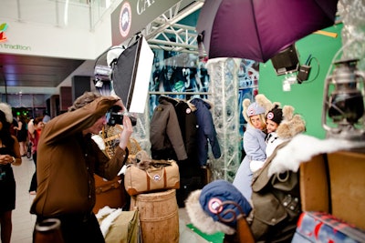Guests posed in Canada Goose jackets and hats at a sponsor activation in the corridor. The green screen showed mountains in the background.