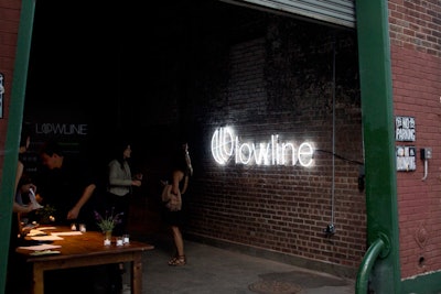 An illuminated sign for the project marked the entrance, guiding guests into the empty warehouse space that served as the site for the event.