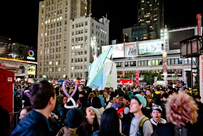 Visitors flocked to Dundas Square for 'Reflexion,' Scotiabank's sponsored installation. Videos, colours, and live shots of the crowd served as the dynamic visuals projected onto the angular sculpture.